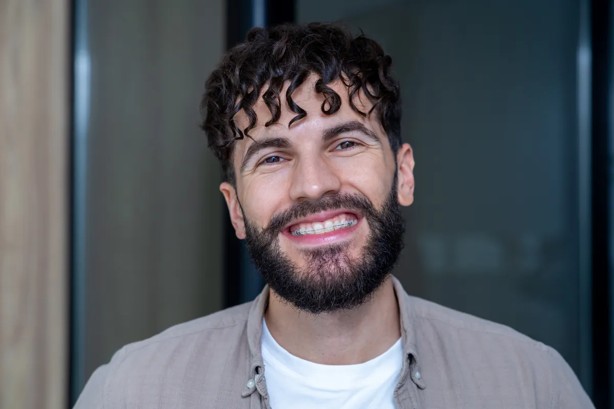 A patient smiling after their braces have been removed
