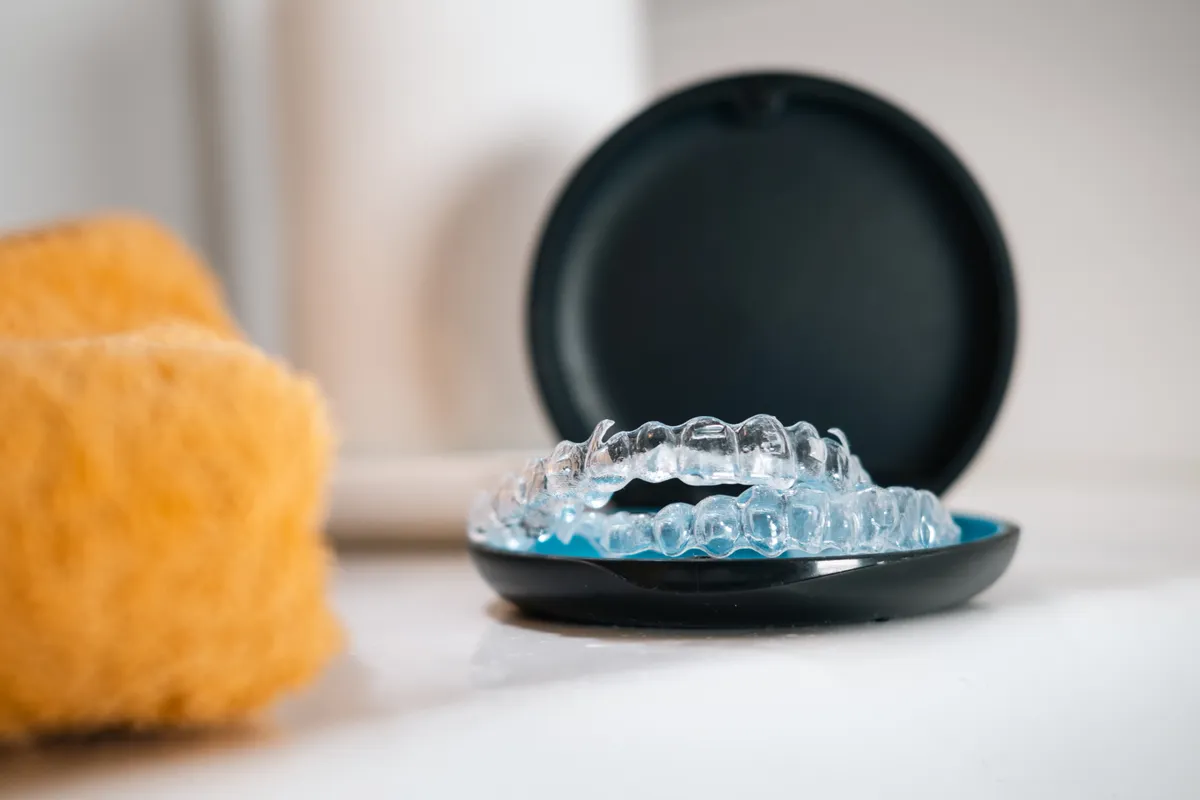 A patient holding a clear Invisalign aligner