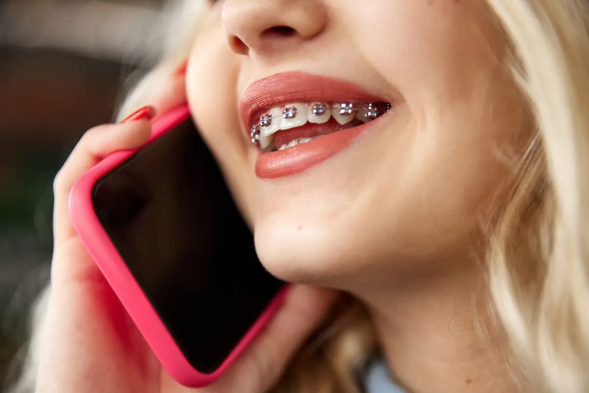 An orthodontist checking a patient's braces and gums