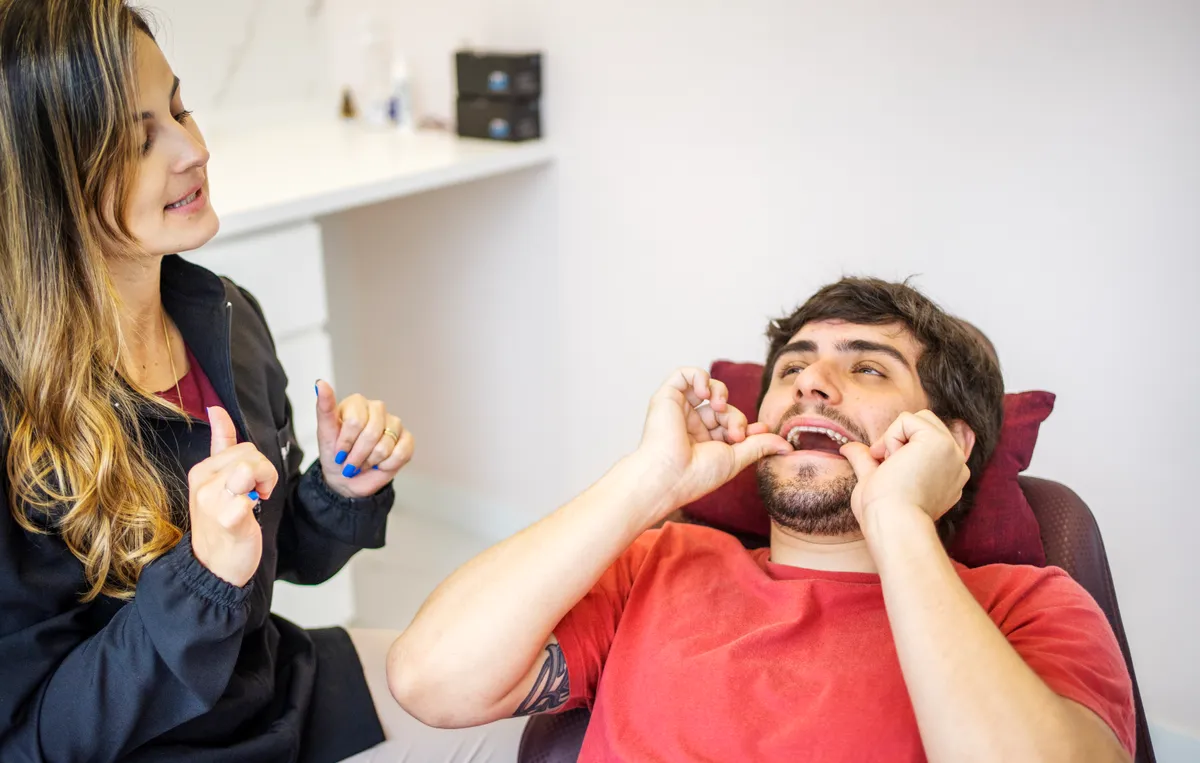 A patient inserting a clear aligner