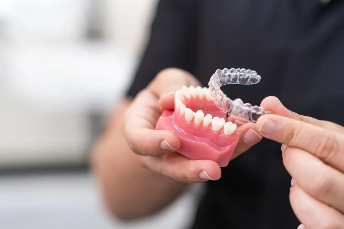 A patient holding their clear aligner