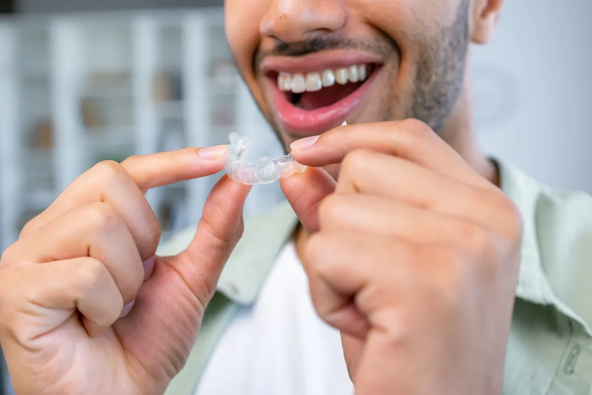 A patient inserting her clear aligner