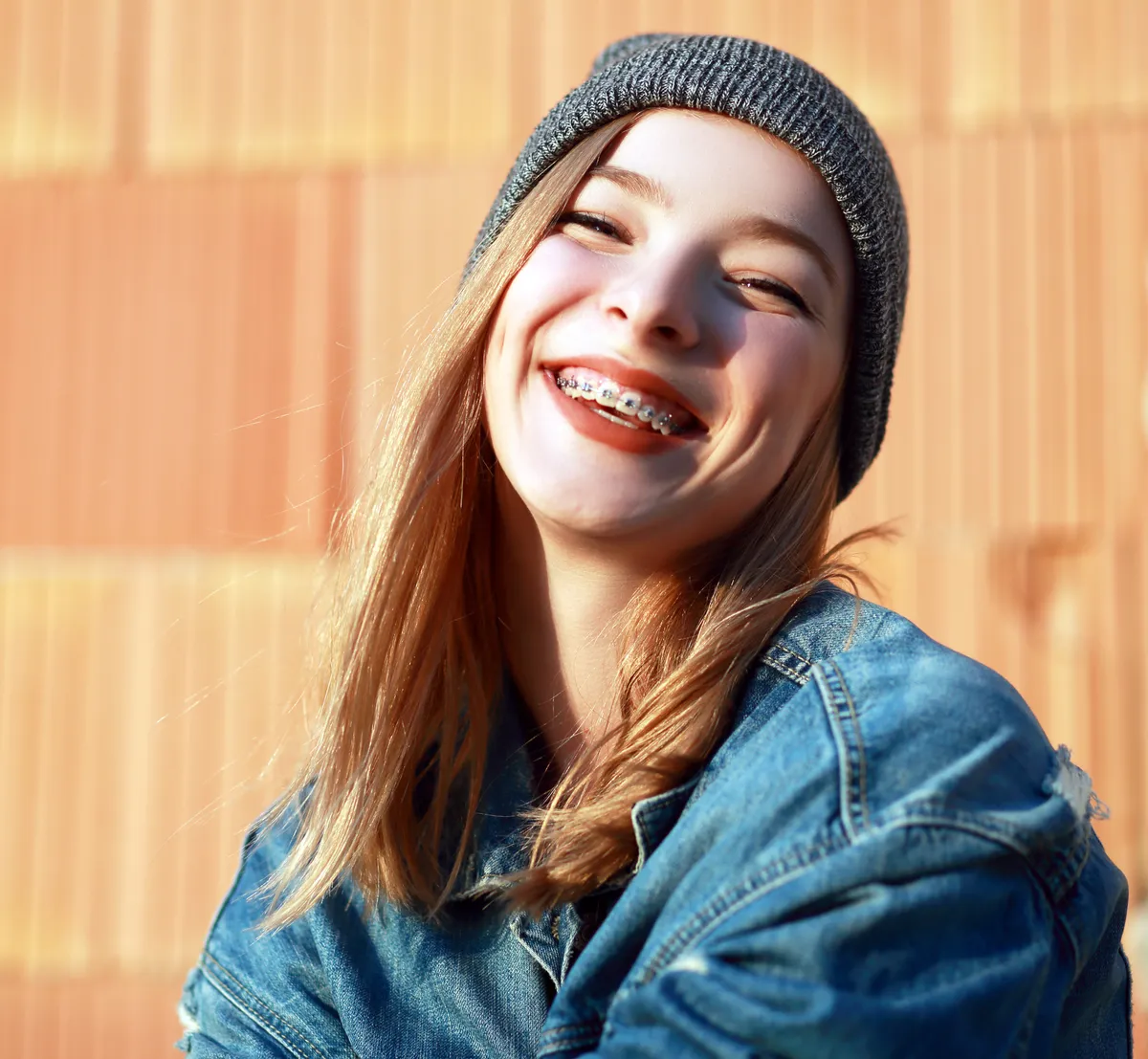 A teenager smiling confidently while wearing metal braces